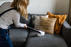 person cleaning the sofa